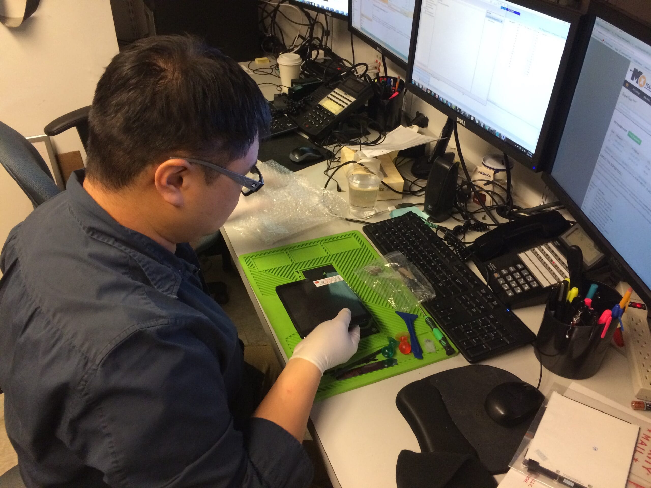 Tech Support NYC technician troubleshooting a multi-monitor computer setup during an on-site repair visit